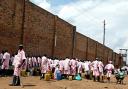 Francine Orr_LAT_Men in pink uniforms stand outside Nsinda prison near Kigali